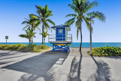 a blue life guard shack on the beach with palm trees at Desoto 2 bedrooms first floor in Hollywood