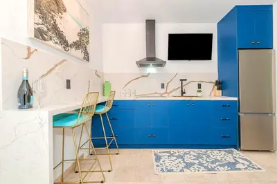 a kitchen with blue cabinets and a sink at Boardwalk Steps from the Beach in Miami Beach