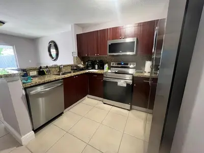 a kitchen with wooden cabinets and stainless steel appliances at Vacation QJR in Cutler Bay