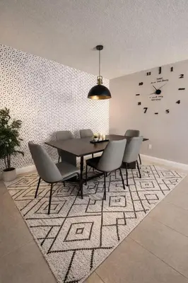 a dining room with a table and chairs on a rug at Vacation QJR in Cutler Bay