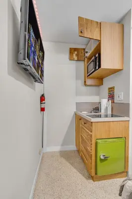 a kitchen with a sink and a tv on a wall at Compact Miami Suite in Miami