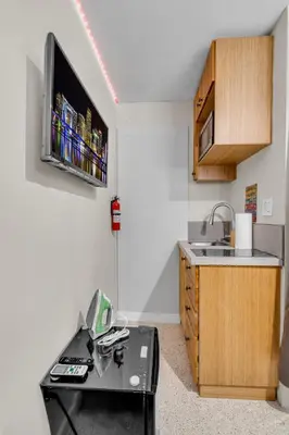 a small kitchen with a tv hanging on the wall at Compact Havana Suites - With Self Check-in in Miami