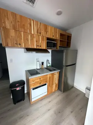 a kitchen with wooden cabinets and a stainless steel refrigerator at Prime Brickell Suites - One Free Parking With Self Check-in in Miami