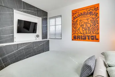 a living room with a couch and a tv at Tropical backyard with pool 10 min from Miami Beach! in Miami
