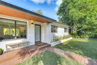 a house with a wooden deck with a yard at Tropical backyard with pool 10 min from Miami Beach! in Miami