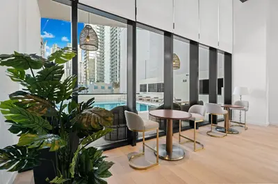 a room with a pool and tables and chairs at Prime Downtown Location - Amazing Amenities & Top Location in Miami