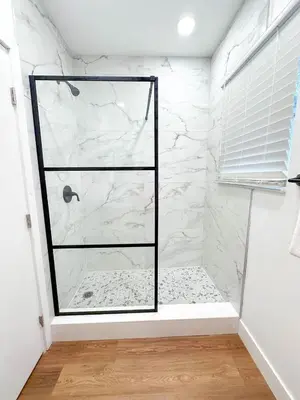 a bathroom with a shower with white marble at Family Pool Retreat 3 BR House for more than 8 Guests in Hollywood
