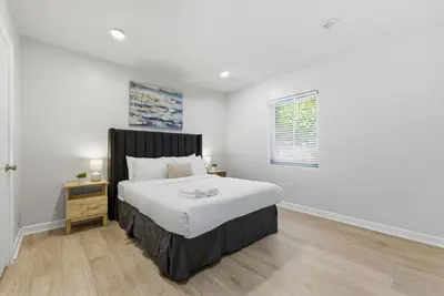a white bedroom with a large bed and a window at Prime Location Miami House W Free Parking in Miami