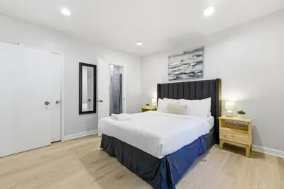 a bedroom with a large white bed and a wooden floor at Prime Location Miami House W Free Parking in Miami