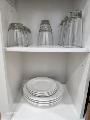 a shelf with plates and glass jars in a refrigerator at Private & Quiet Retreat Near Hard Rock Stadium and Guitar Hotel in Pembroke Pines