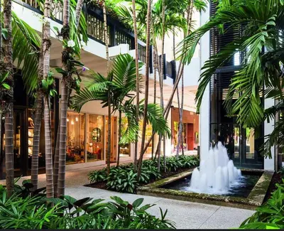 a courtyard with palm trees and a fountain in front of a building at NEW House, Near Beaches, and MIA, Sleeps 8! in Westview