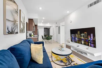 a living room with a blue couch and a tv at Brickell Border 3BR by Untitled Stay in Miami