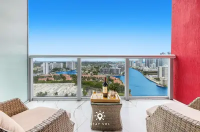 a balcony with a bottle of wine on a table at Spacious 2BR apt - Amazing Balcony View in Hallandale Beach
