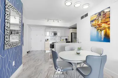 a kitchen and dining room with a white table and chairs at One Bedroom - Amazing Balcony in Hallandale Beach
