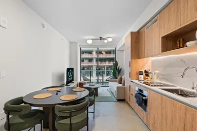 a kitchen and living room with a table and chairs at Skyline Views - Steps from Bayfront Park in Miami
