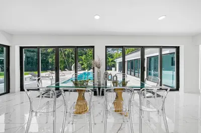 a dining room with a glass table and chairs at Two Neighboring Villas in The Heart of Miami in Miami