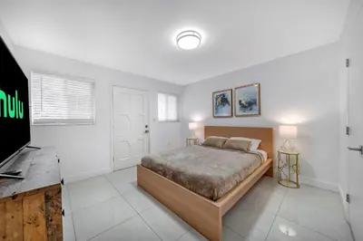 a bedroom with a bed and a flat screen tv at Two Neighboring Villas in The Heart of Miami in Miami