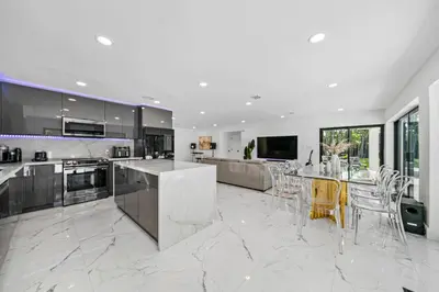 a large kitchen with white marble floors and appliances at Two Neighboring Villas in The Heart of Miami in Miami