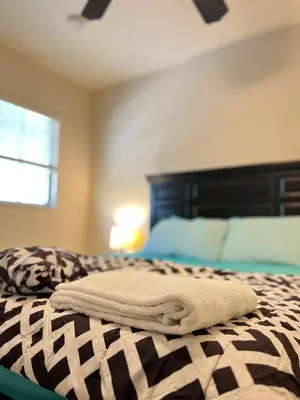 a bed with a towel on top of it at Queen with Private Dedicated Spa Bath in Miami