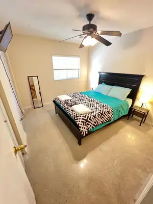 a bedroom with a bed and a ceiling fan at Queen with Private Dedicated Spa Bath in Miami