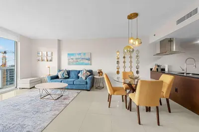 a living room with a blue couch and a table at Luxury Waterfront W Hotel Condo Brickell Skyline Views in Miami