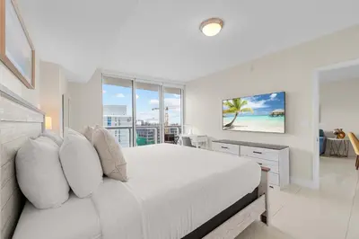 a white bedroom with a bed and a large window at Luxury Waterfront W Hotel Condo Brickell Skyline Views in Miami