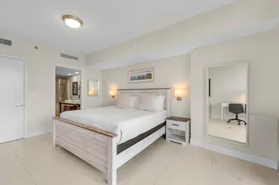 a white bedroom with a bed and a mirror at Luxury Waterfront W Hotel Condo Brickell Skyline Views in Miami