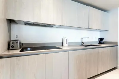 a kitchen with white cabinets and a sink at Luxury Condo with Beach Access in Hollywood