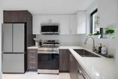 a kitchen with white cabinets and a stainless steel refrigerator at 2BR near Bal Harbour beautiful in Miami Beach