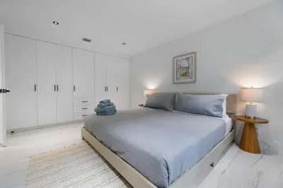 a white bedroom with a bed and white cabinets at 2BR near Bal Harbour beautiful in Miami Beach