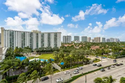 a large building in a city with palm trees at Beachfront Resort Studio with 2 Queen beds, Balcony & Pool in Sunny Isles Beach