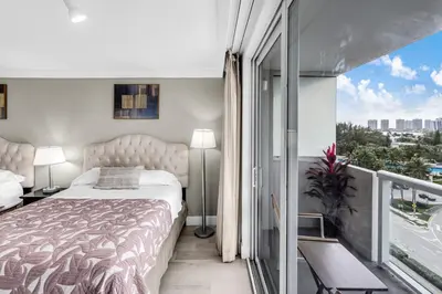a bedroom with a large bed and a balcony at Beachfront Resort Studio with 2 Queen beds, Balcony & Pool in Sunny Isles Beach