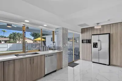 a kitchen with a stainless steel refrigerator and a balcony at Large corner Villa with Pool Table and Private Pool in Hollywood