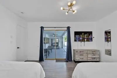 a white room with two beds and a sliding glass door at Large corner Villa with Pool Table and Private Pool in Hollywood