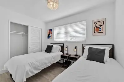 a bedroom with two beds and a table and a chandelier at Large corner Villa with Pool Table and Private Pool in Hollywood