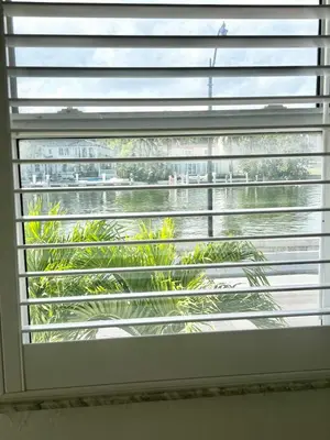 a window with blinds on it with a palm tree at Waterviews studio at the beach #mybeachspotmiami in Miami Beach