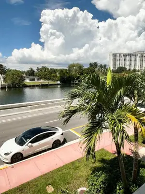 a white car driving down a road next to a palm tree at Waterviews studio at the beach #mybeachspotmiami in Miami Beach