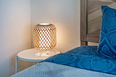 a bed with a lamp on a table next to a bed at Art Deco Gem by the Beach King Bed & Parking in Miami Beach