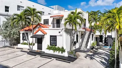 a white house with palm trees in front of it at Art Deco Gem by the Beach King Bed & Parking in Miami Beach