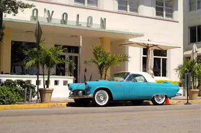 a blue car parked in front of a building at Art Deco Gem Steps to Beach in Miami Beach