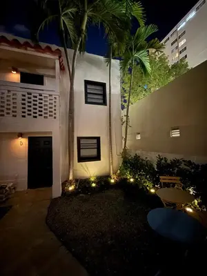 a white building with a palm tree and lights at Steps from Ocean Art Deco 1BR & Free Parking in Miami Beach