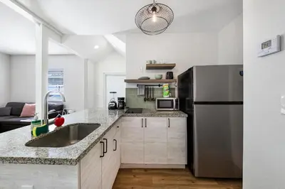 a kitchen with a sink and a refrigerator at Art Deco Escape Steps to Ocean & Free Parking in Miami Beach