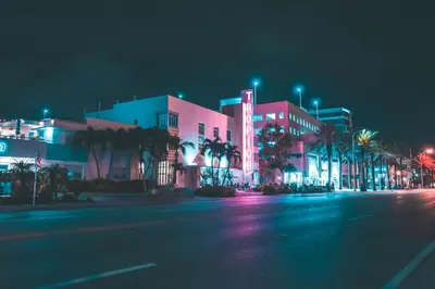 an empty street in front of a building at night at Art Deco Escape Steps to Ocean & Free Parking in Miami Beach