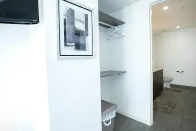 a bathroom with a toilet and a television on a wall at Downtown Miami 2BR Retreat - Walk to Bayside & Port - Sleeps 6 in Miami