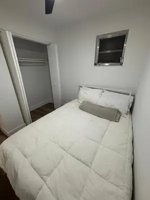 a bedroom with a large white bed with a window at CG Miami House in Miami