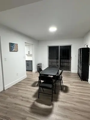 an empty living room with a table and chairs at CG Miami House in Miami