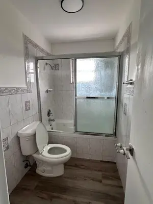 a bathroom with a toilet and a tub and a window at CG Miami House in Miami