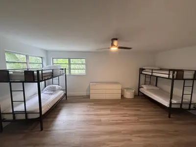 a room with three bunk beds and a ceiling fan at CG Miami House in Miami