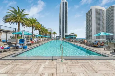 a swimming pool with palm trees and buildings at Hyde Dream Penthouse in Hollywood