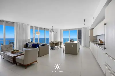 a living room with a couch and chairs and a kitchen at Oceanline 3BR Corner Balcony & Calm Seas in Hollywood